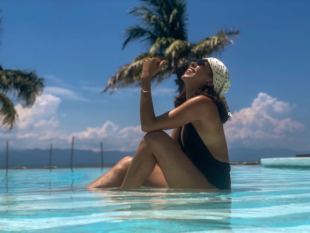 girl wearing black swimsuit in a beautiful beach.
