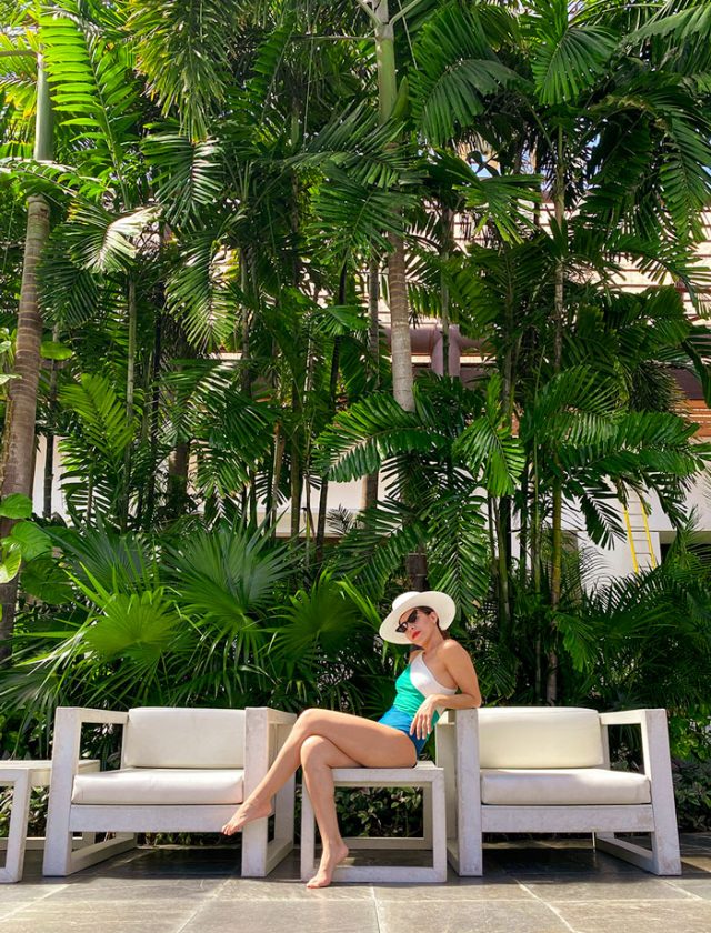 Girl wearing summer salt with a background of palm trees