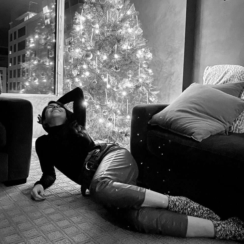 picture of a woman in front of a christmas tree